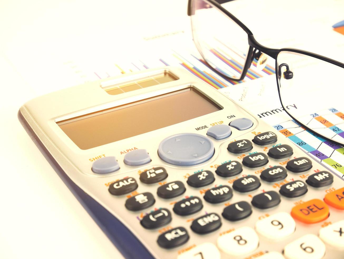 Gráfico de negocios cerca de la calculadora con gafas desenfocadas, concepto financiero foto