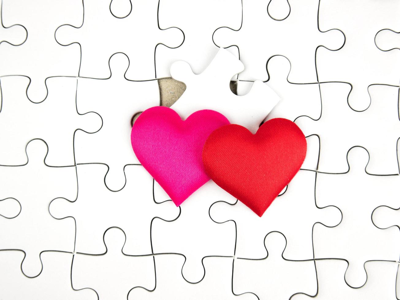Colorful mini hearts on jigsaw puzzle pieces background, Valentine decorations, Various hearts photo