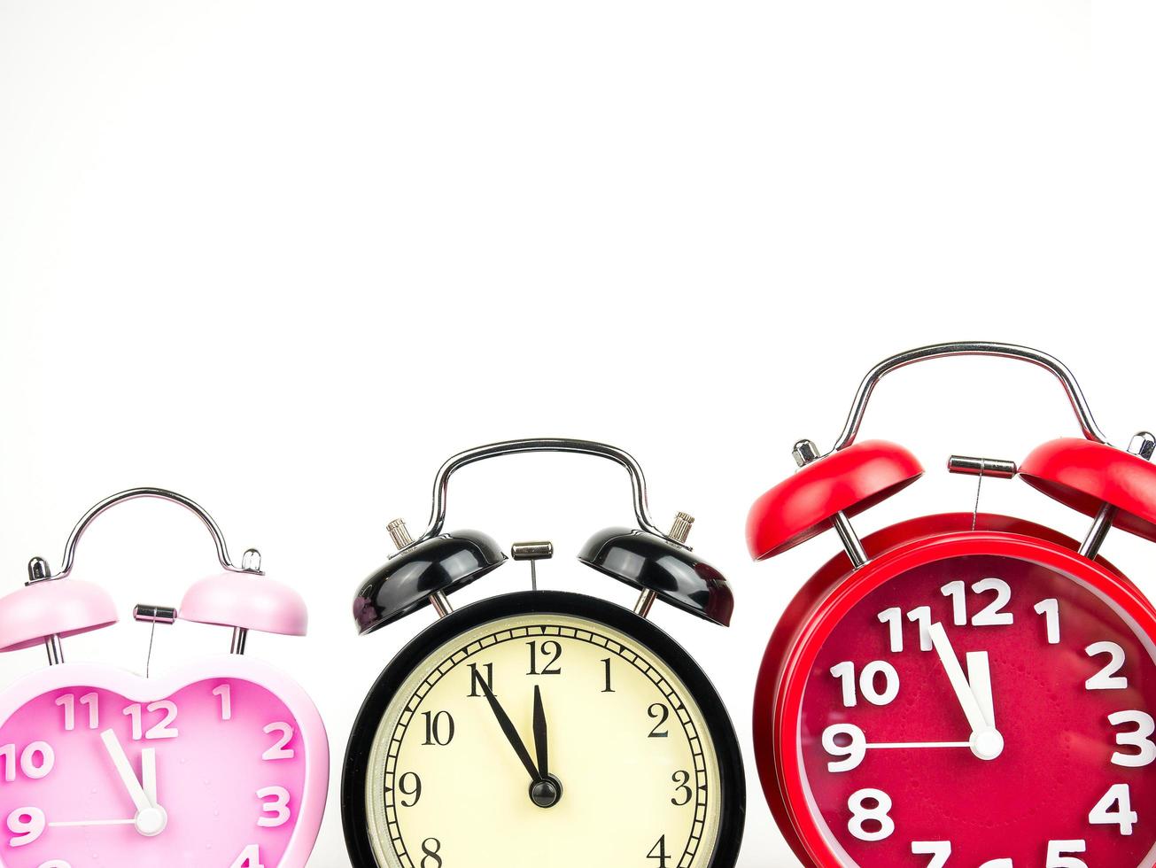 Three alarm clock, red, pink, black isolated on white background photo