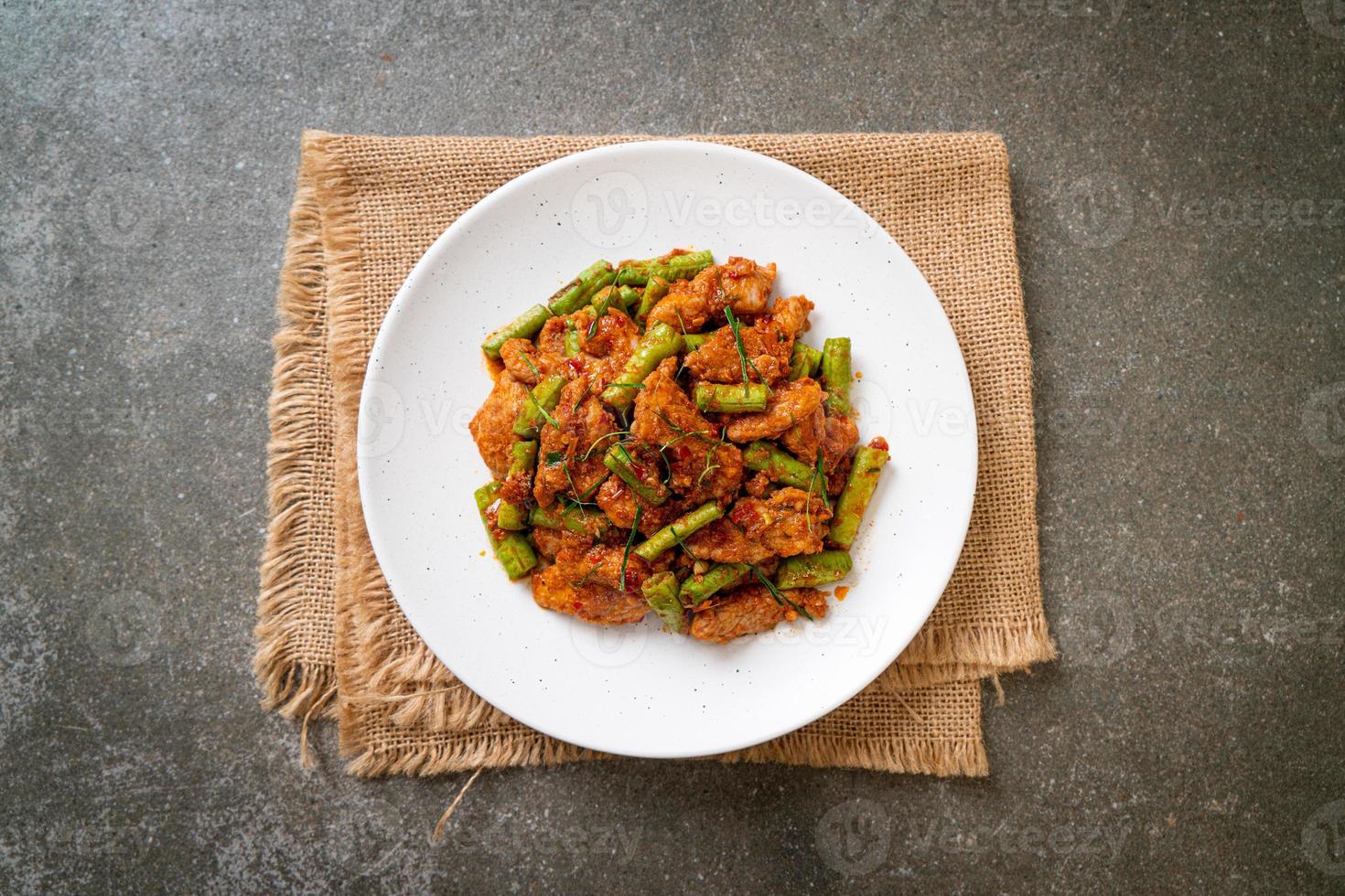 salteado de cerdo frito y pasta de curry rojo con frijoles picantes foto