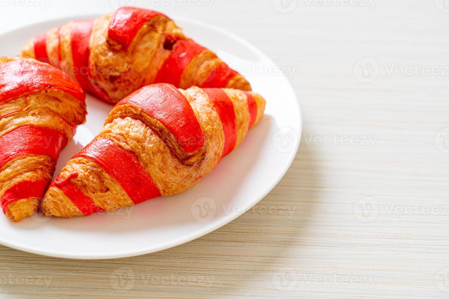 croissant fresco con salsa de mermelada de fresa foto