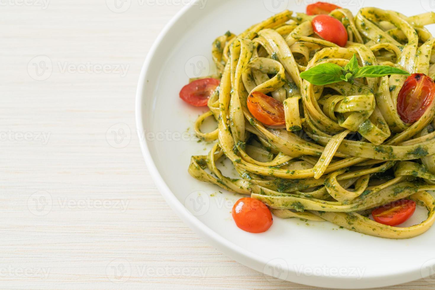 fettuccine spaghetti pasta with pesto sauce and tomatoes photo