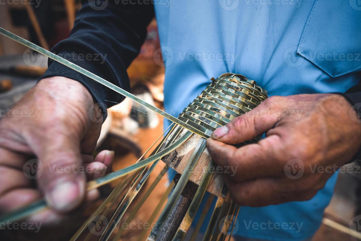 manos tejiendo cestas de bambú en casa foto