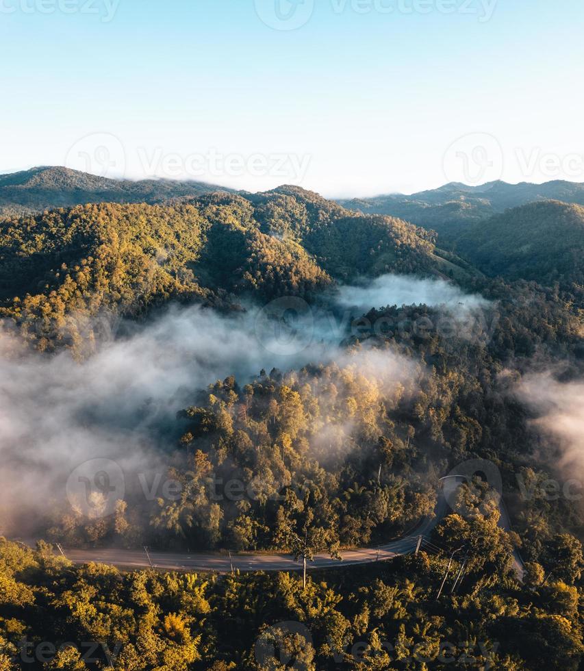 el sol sale en la niebla y las montañas por la mañana foto