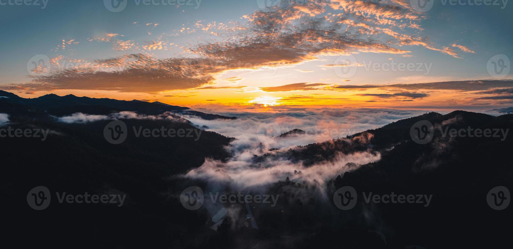 el sol sale en la niebla y las montañas por la mañana foto