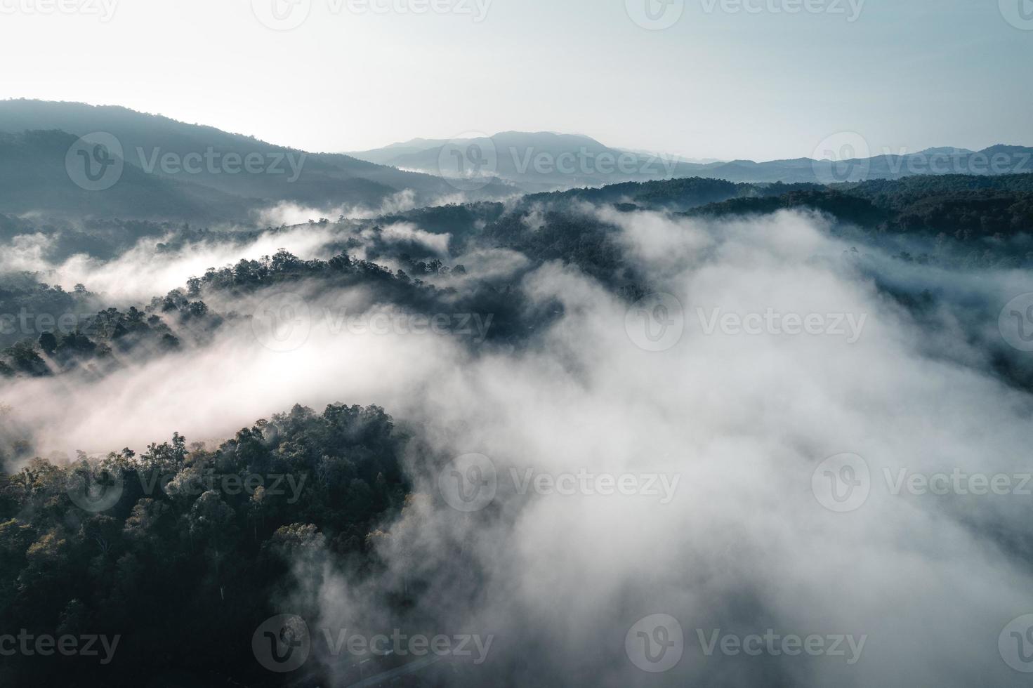 el sol sale en la niebla y las montañas por la mañana foto