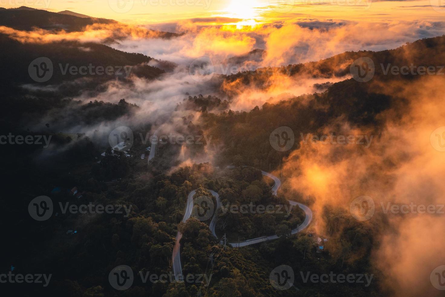 el sol sale en la niebla y las montañas por la mañana foto