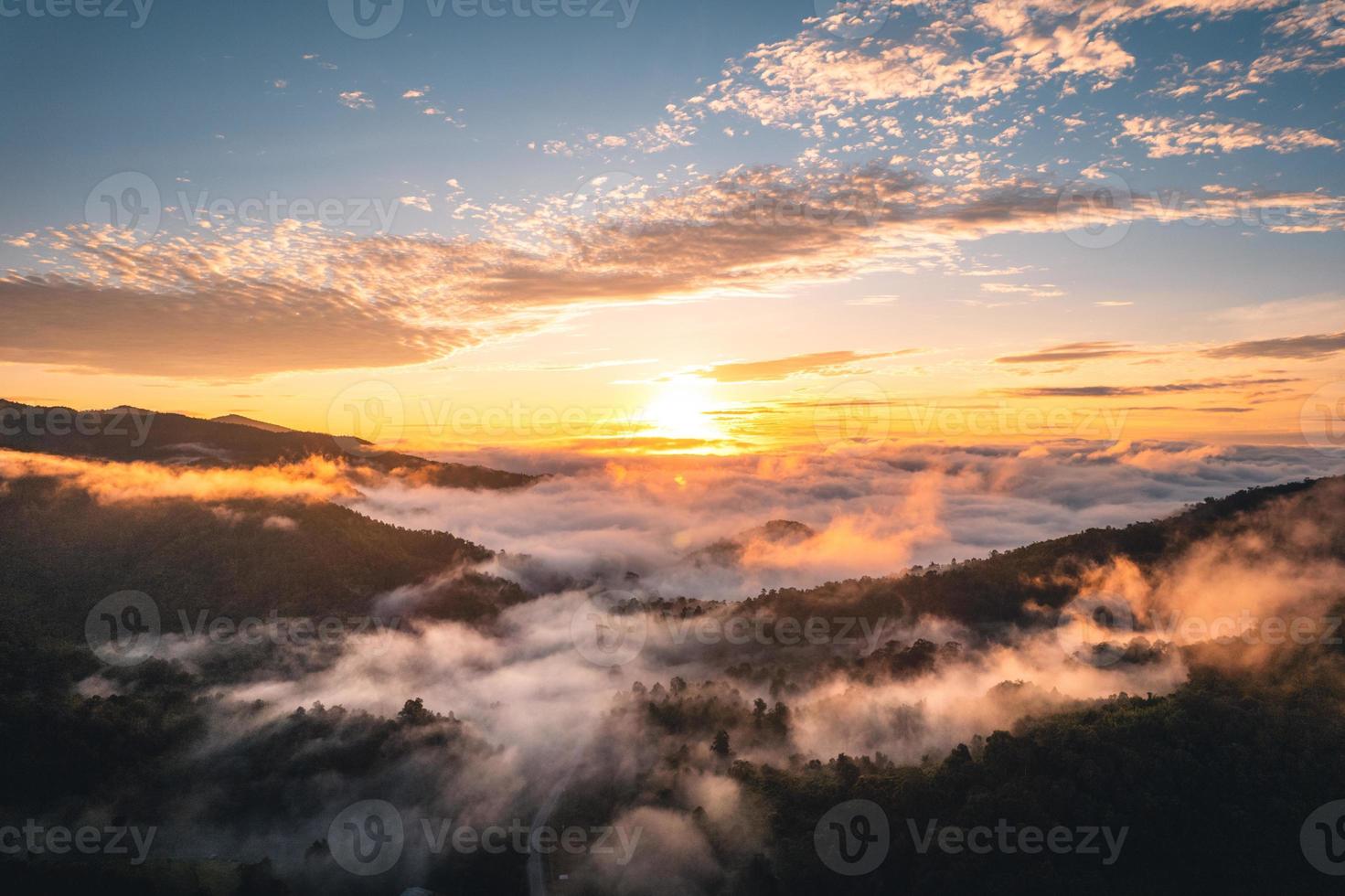 el sol sale en la niebla y las montañas por la mañana foto