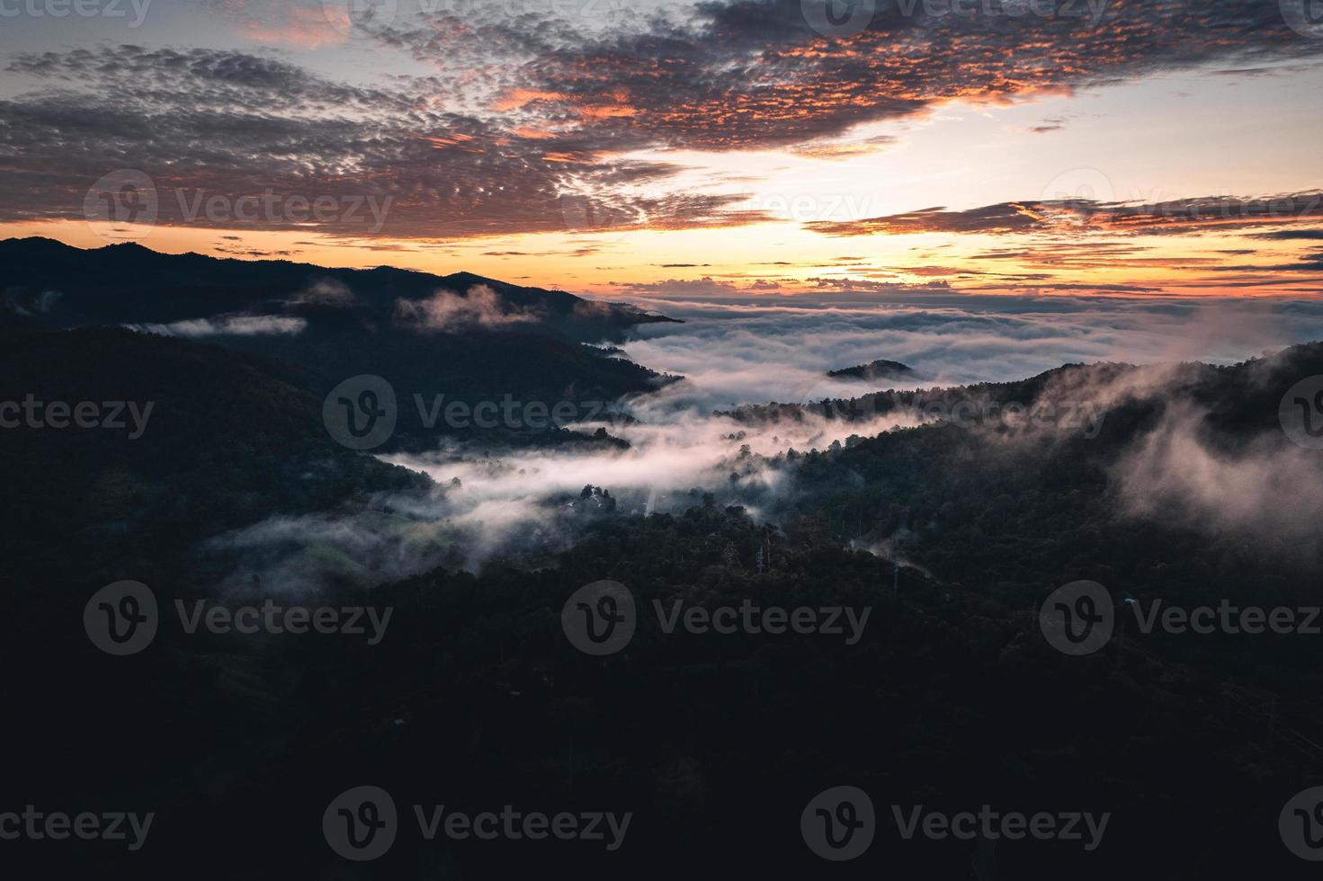 el sol sale en la niebla y las montañas por la mañana foto