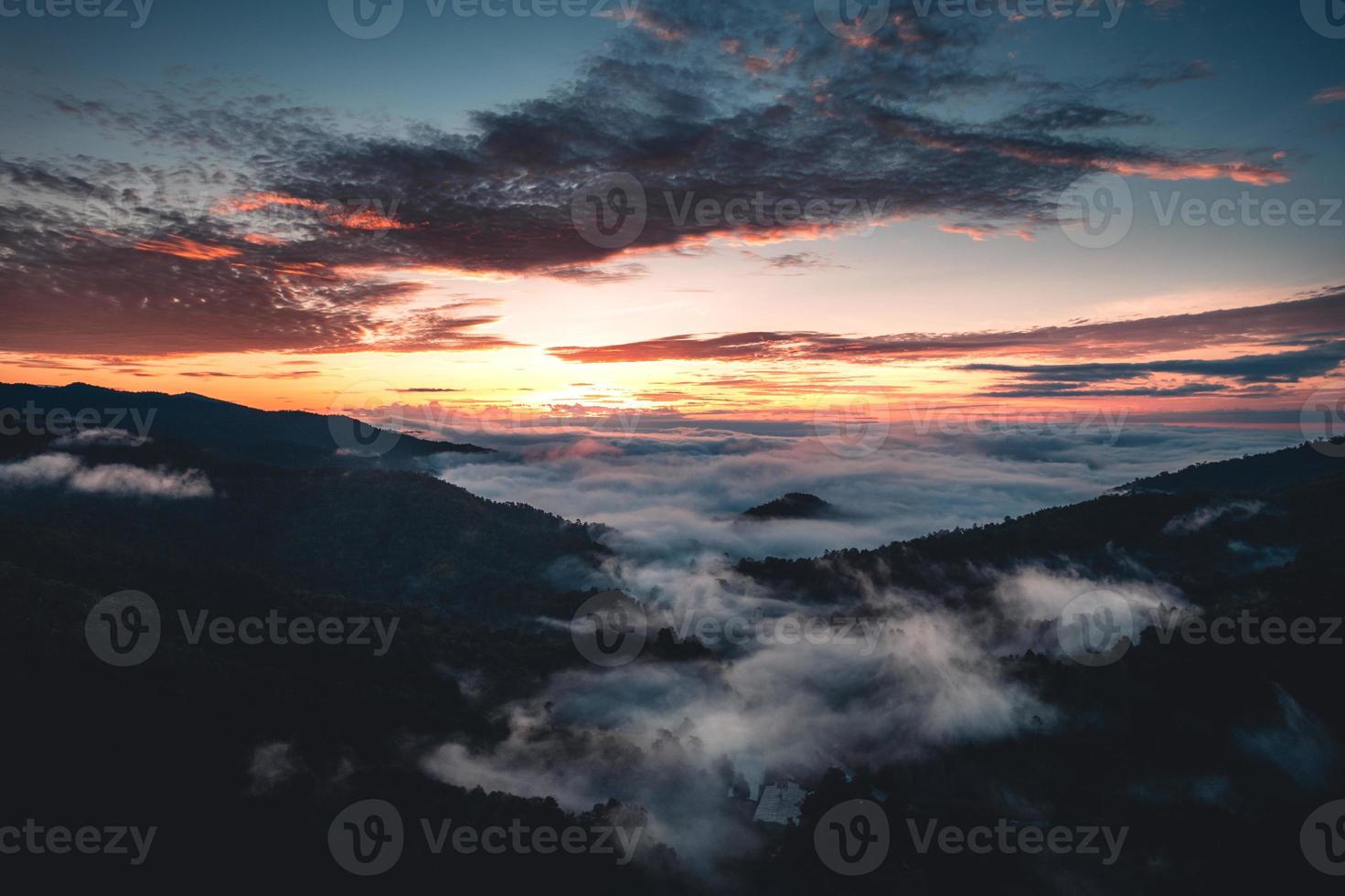 el sol sale en la niebla y las montañas por la mañana foto