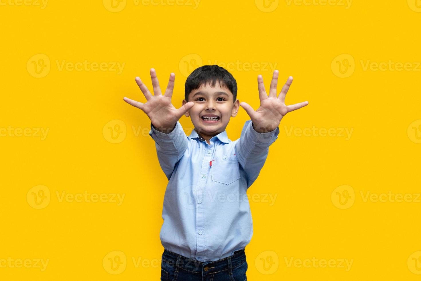 Retrato de niño caucásico emocional en ropa básica disfrutando aislado sobre fondo liso foto