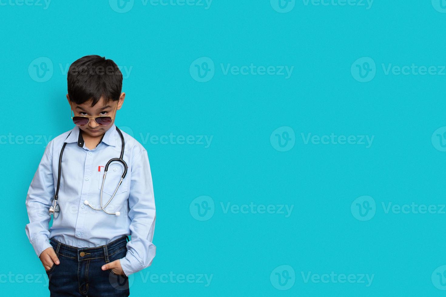 Smiling little boy with stethoscope and glasses isolated background with copy space photo