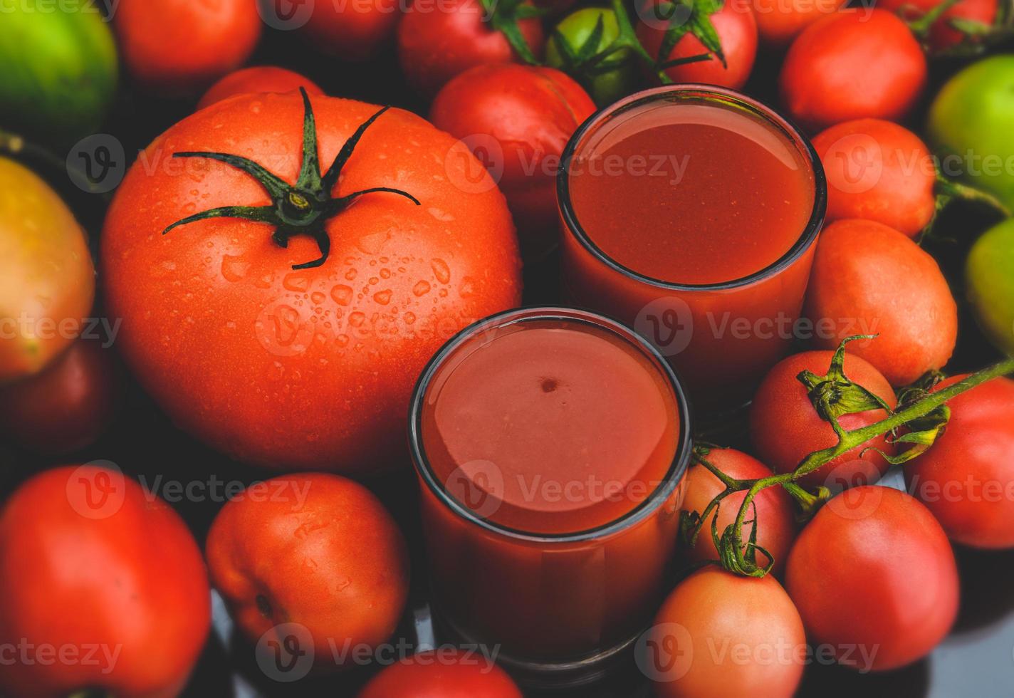 mezcle los tomates y los jugos en un vaso. foto