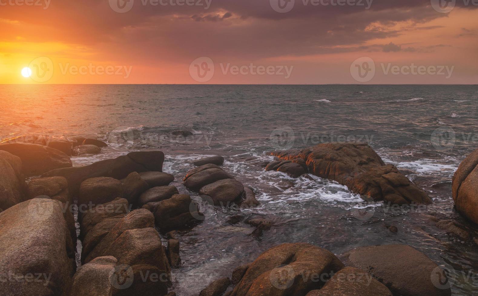 The rock in the sea with dark cloud sky. photo