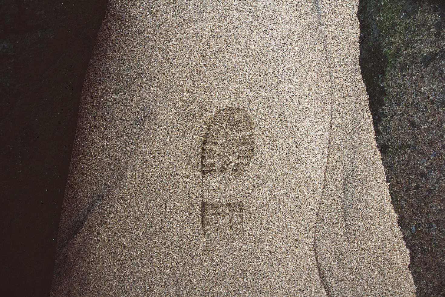 Imprint of shoe on mud with copy space. Foot step on sand photo