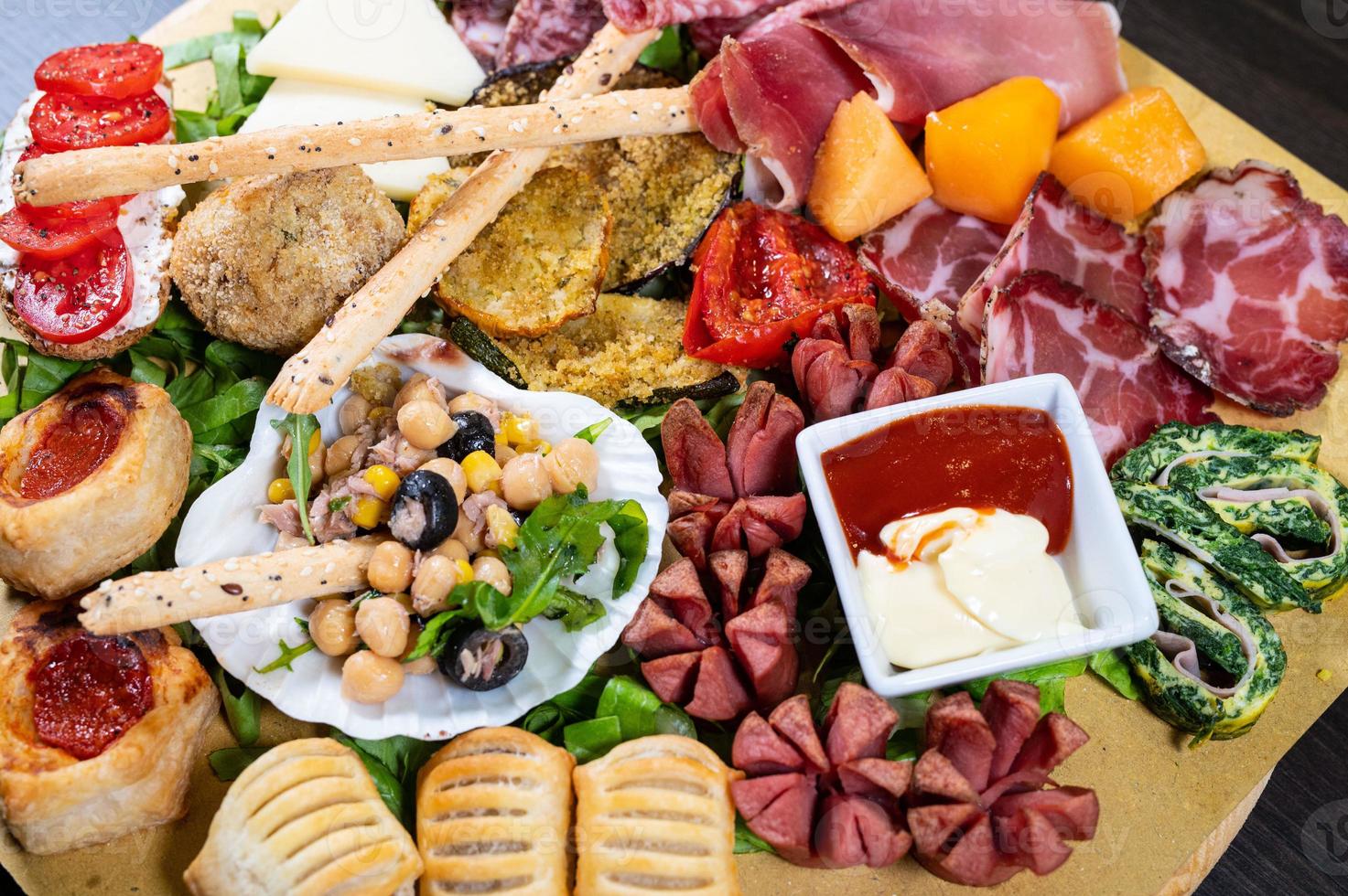 mixed antipasto platter with cold cuts and legumes and cheeses photo