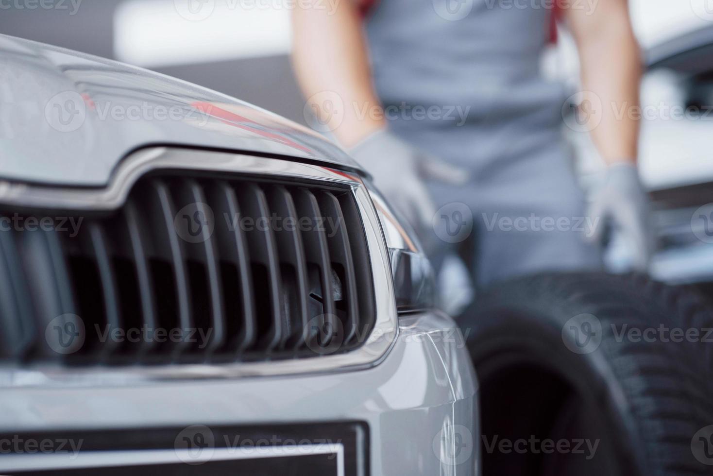 Mechanic holding a tire tire at the repair garage. replacement of winter and summer tires photo