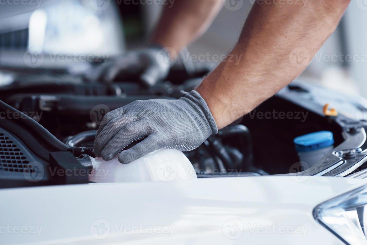 Auto mechanic working in garage. Repair service photo