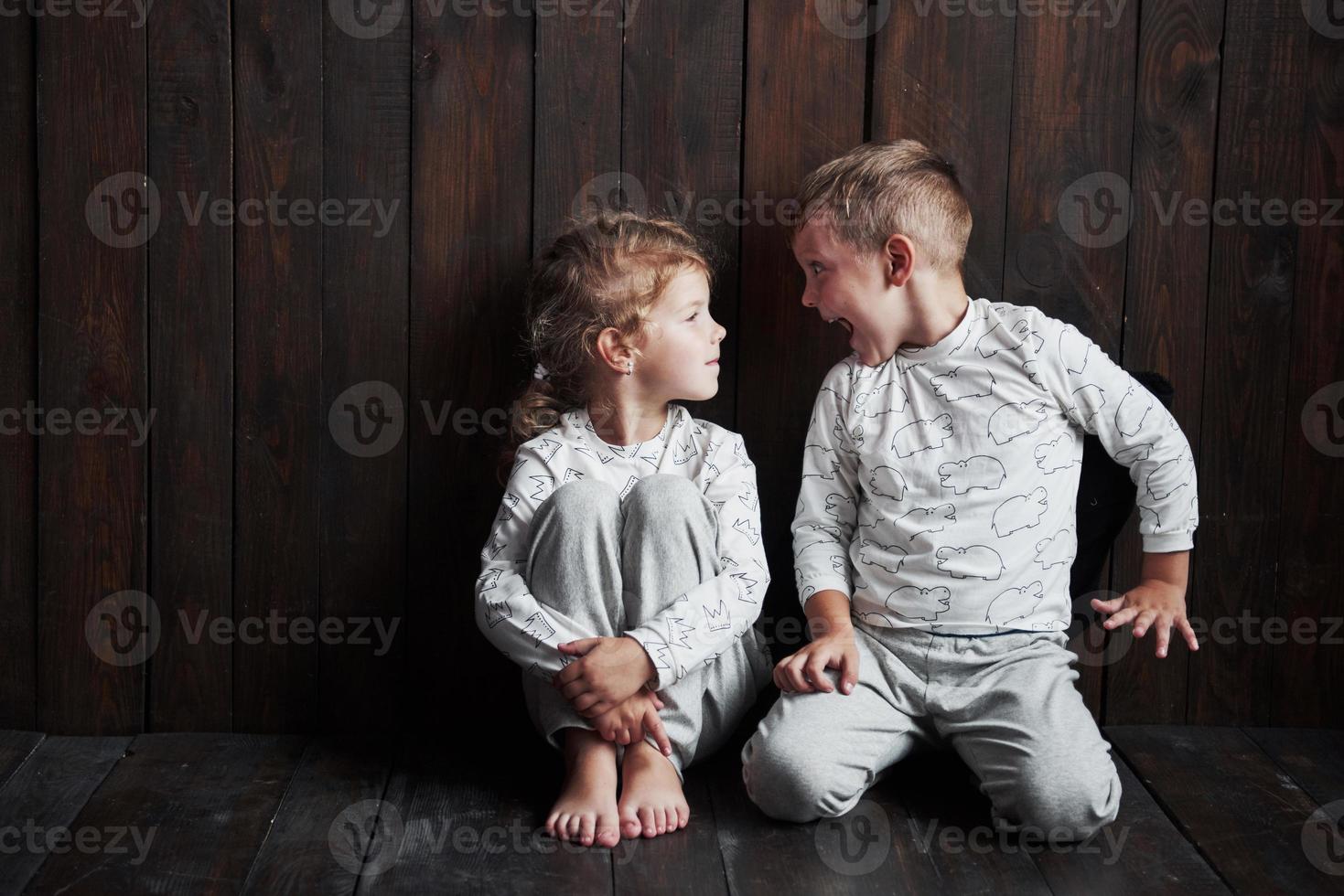 dos niños, hermano y hermana en pijama juegan juntos. foto