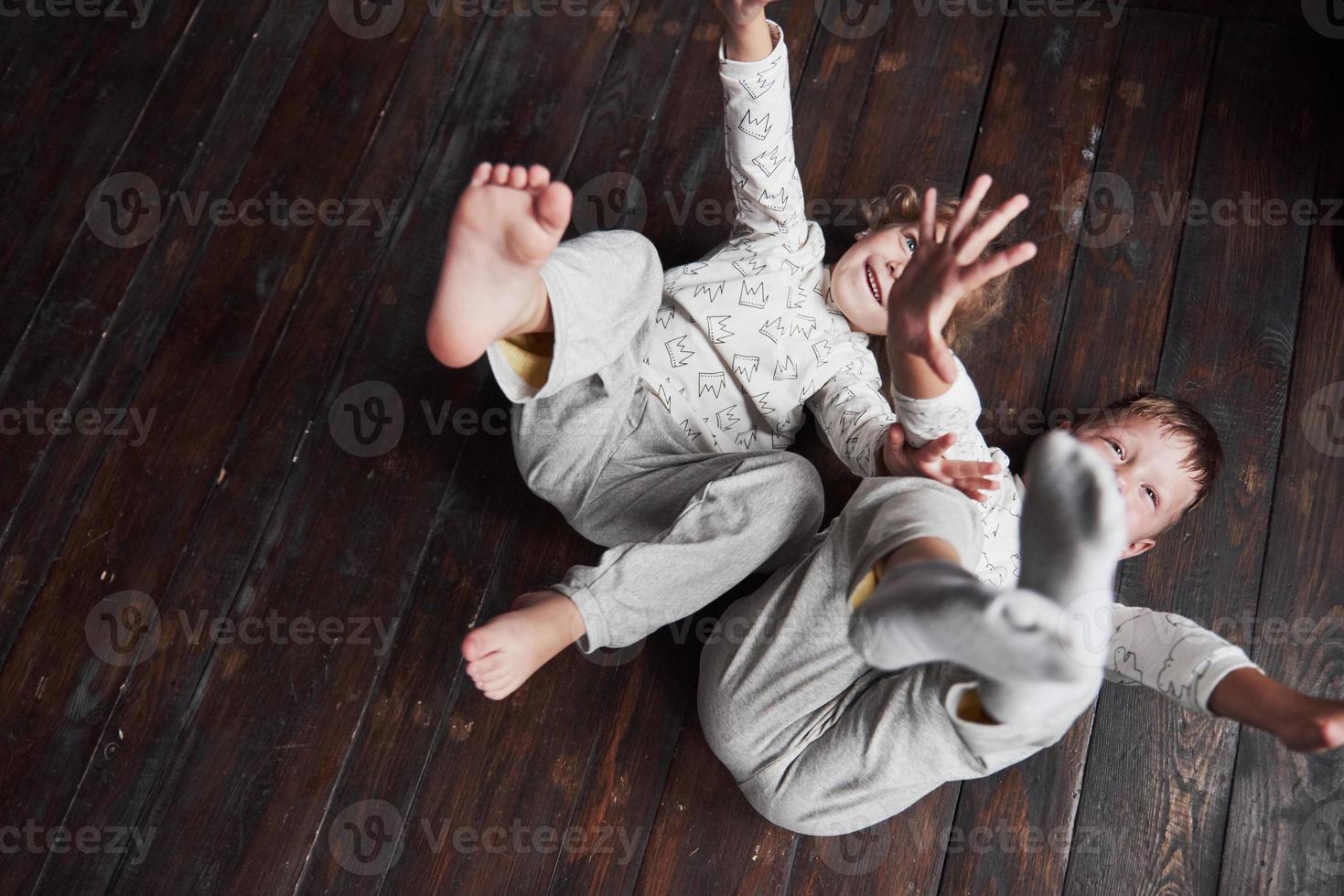 dos niños, hermano y hermana en pijama juegan juntos. foto
