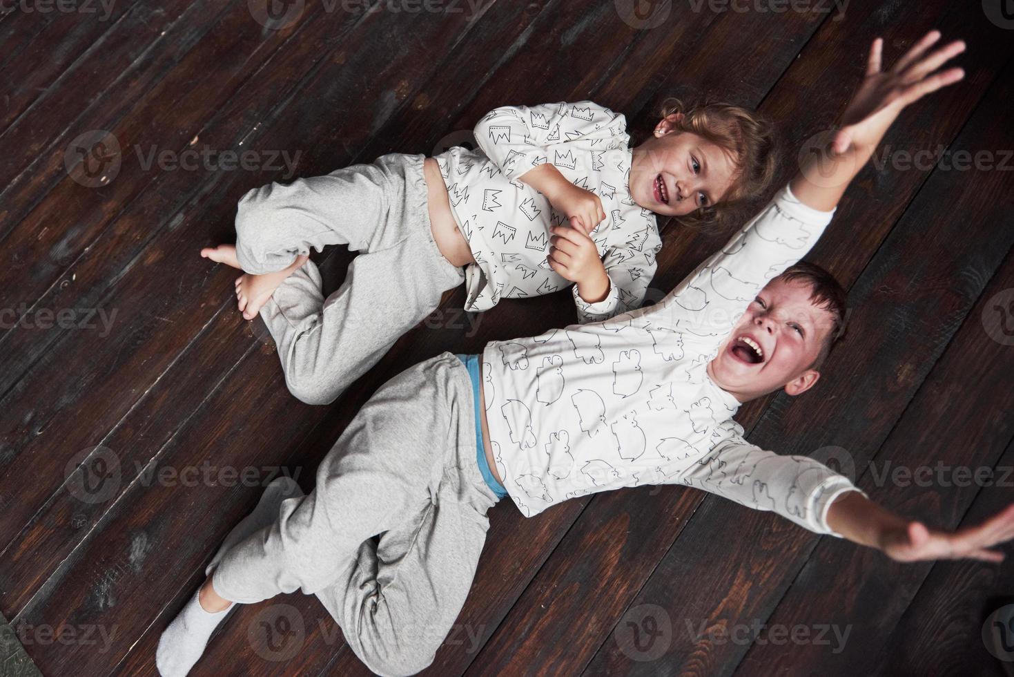 dos niños, hermano y hermana en pijama juegan juntos. foto