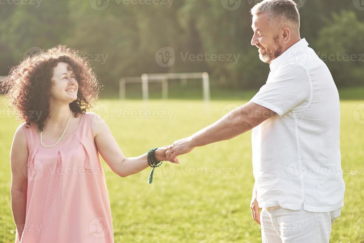 A loving, handsome senior couple outdoors in the park, many years together photo