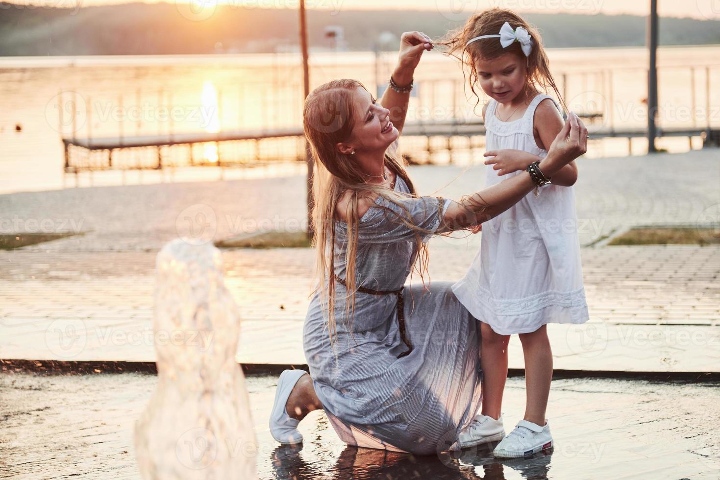 una mujer jugando con un niño cerca del océano en el parque al atardecer foto