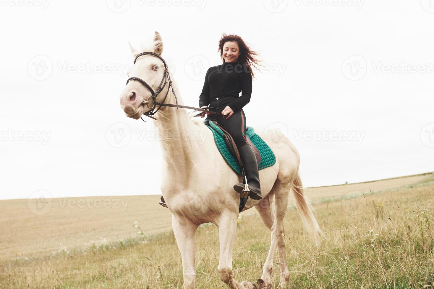 Young pretty girl - riding a horse, equestrian sport in spring time photo