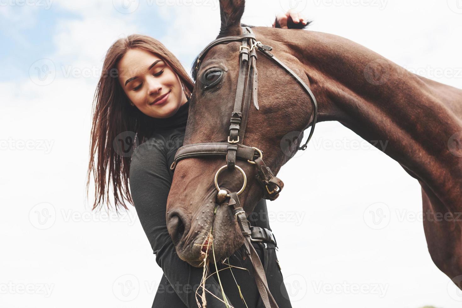 una niña feliz se comunica con su caballo favorito. la niña ama a los animales y a montar a caballo foto