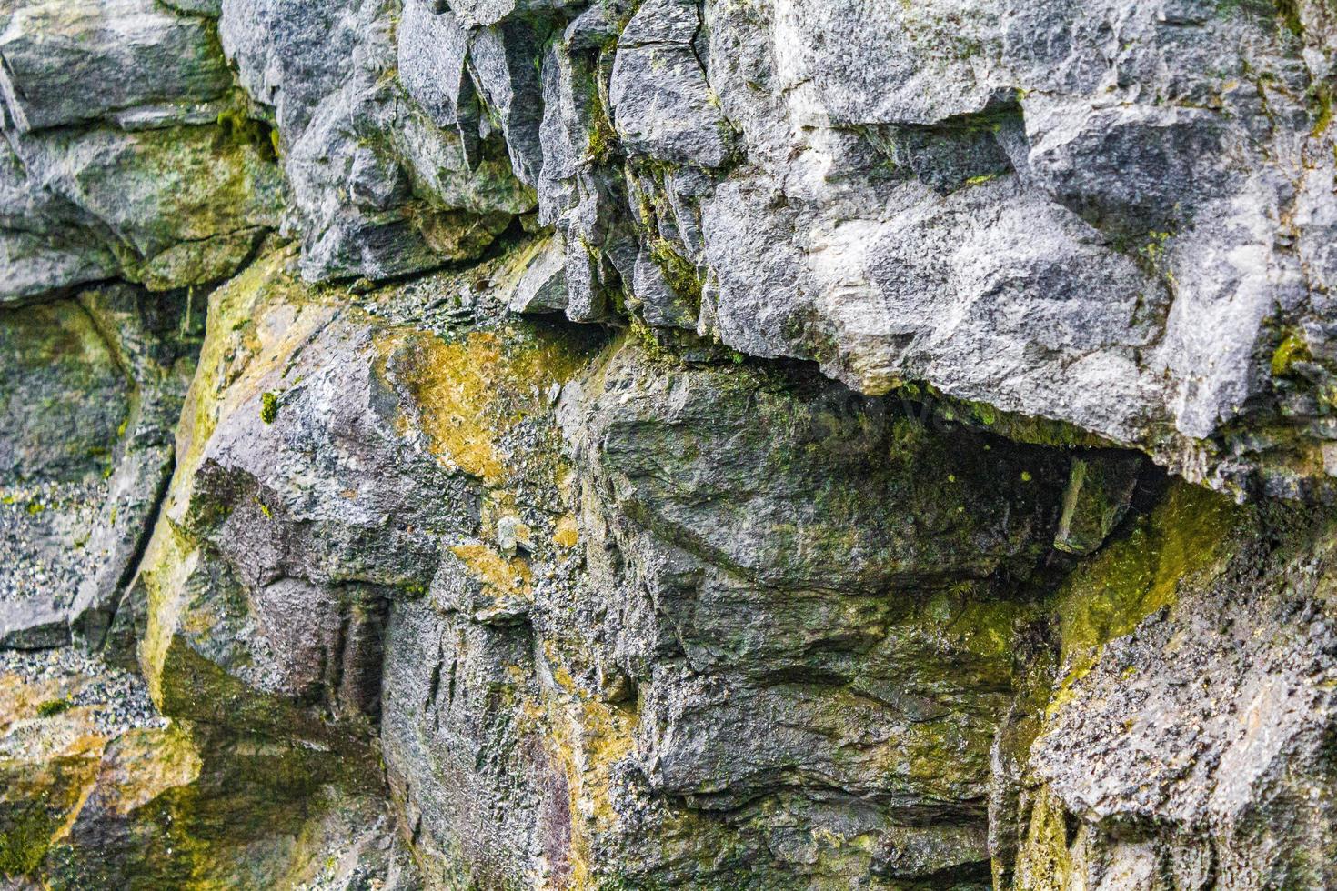 Stone rock texture with green yellow moss and lichen Norway. photo