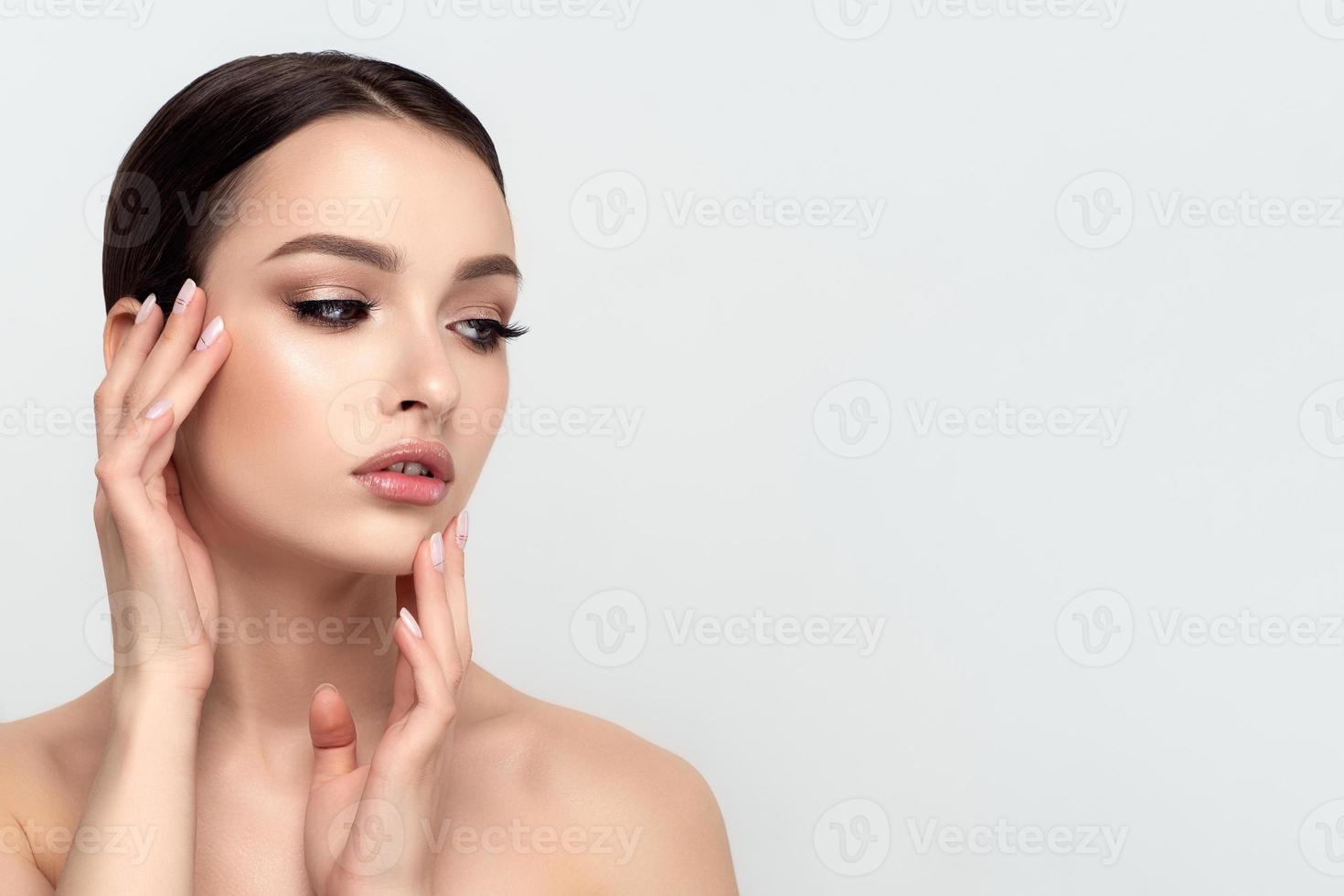 Young beautiful woman touching her face photo