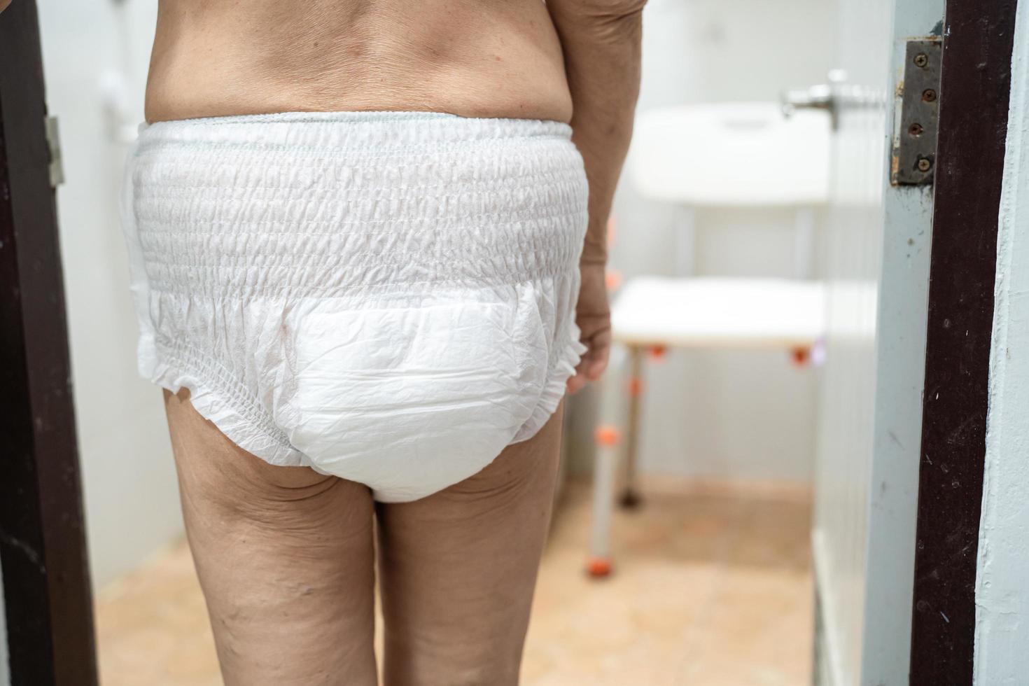 Asian senior or elderly old lady woman patient wearing incontinence diaper in nursing hospital ward, healthy strong medical concept. photo