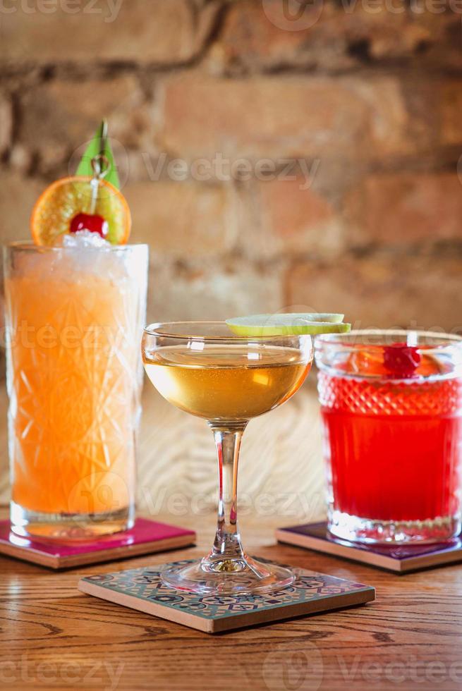 different colorful alcohol and non-alcohol cocktails in the glasses on the table photo