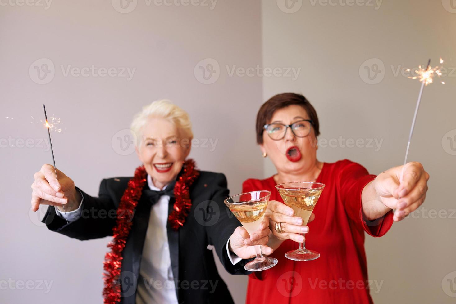 dos hermosas mujeres mayores maduras con estilo celebrando el año nuevo. diversión, fiesta, estilo, concepto de celebración foto