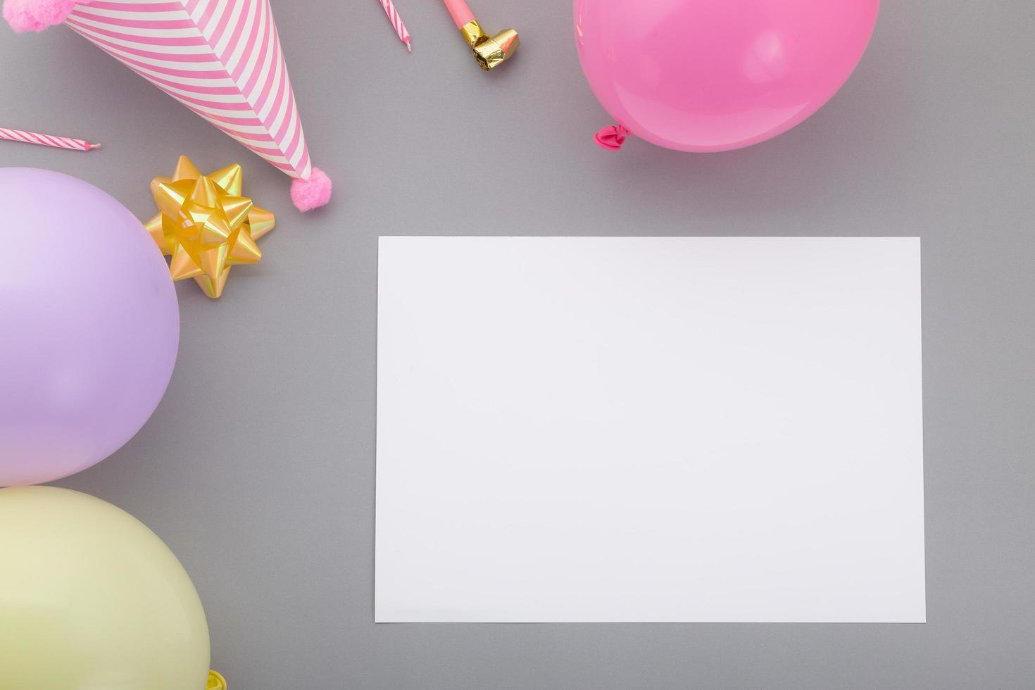Fondo de feliz cumpleaños, decoración de fiesta colorida laicos plana con tarjeta de invitación de volante sobre fondo gris pastel foto