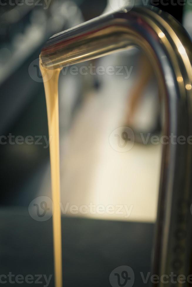 White chocolate flowing from a faucet metal photo