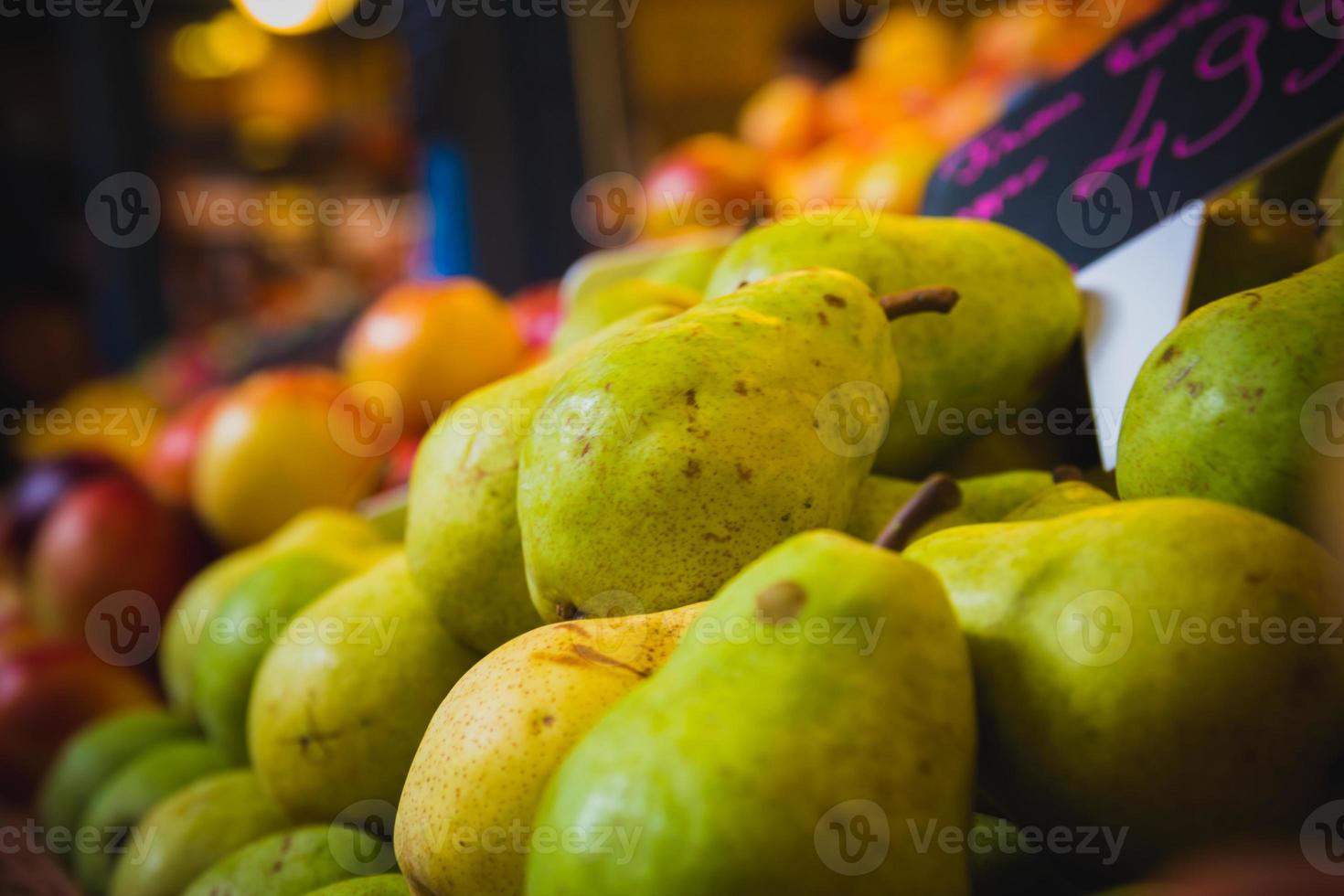 peras y melocotones en un puesto en el mercado de abarrotes foto