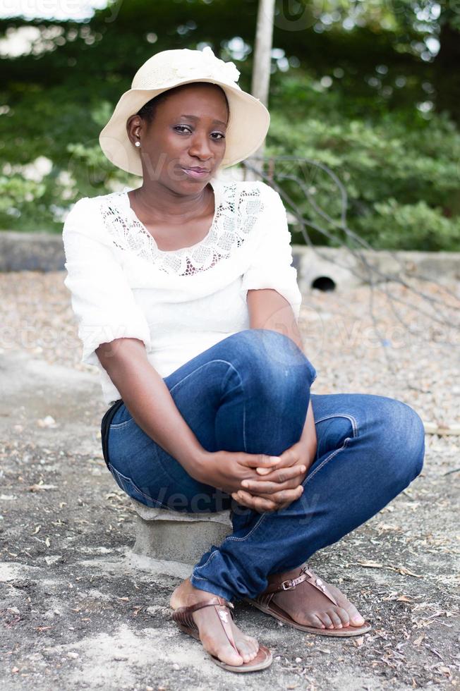 young woman sitting on a piece of brick. photo