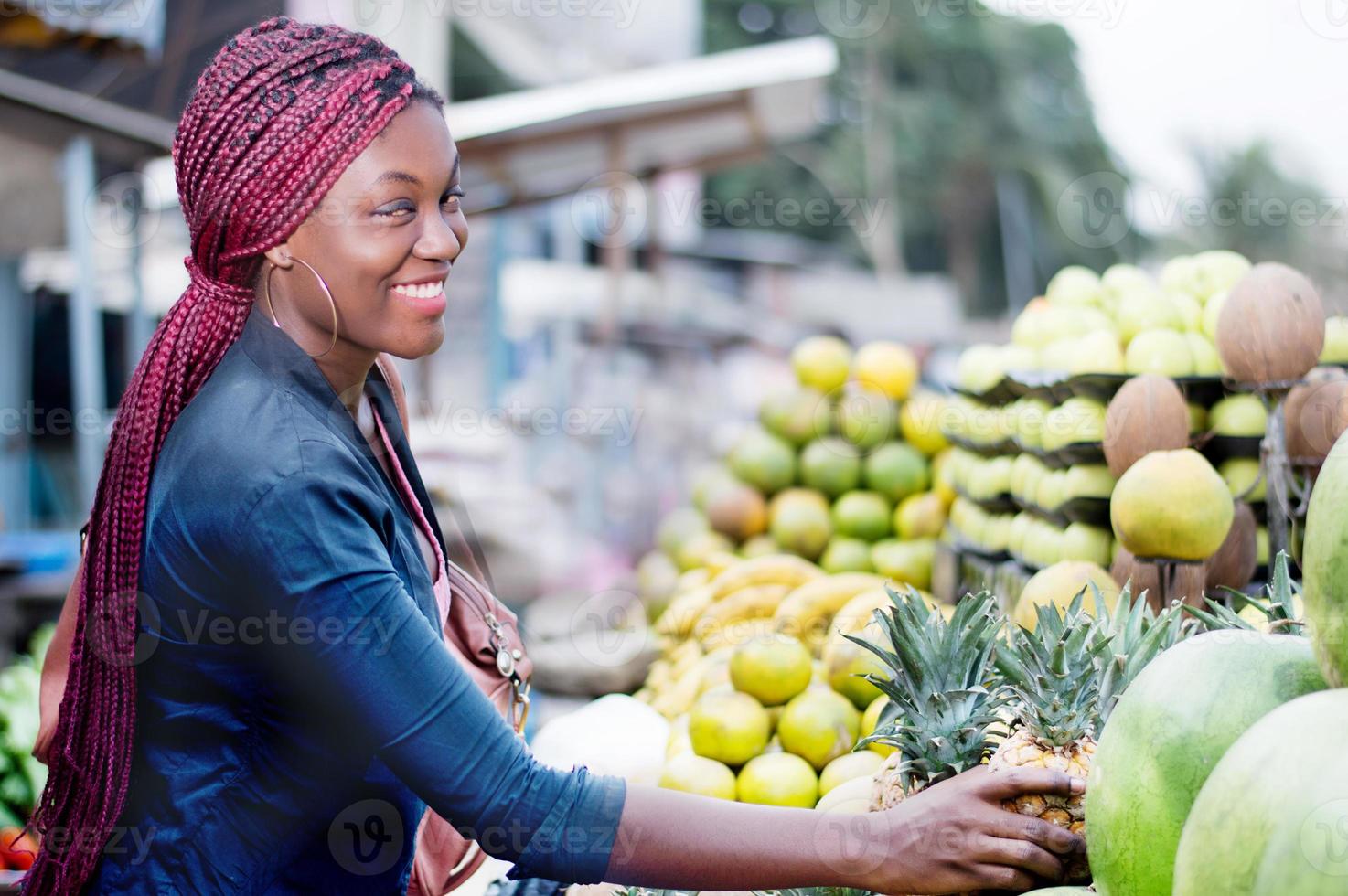 young woman smiling at fruit market photo