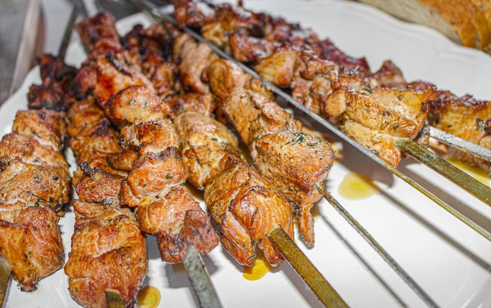 Pinchito ruso con brochetas sobre un fondo de placa blanca. foto