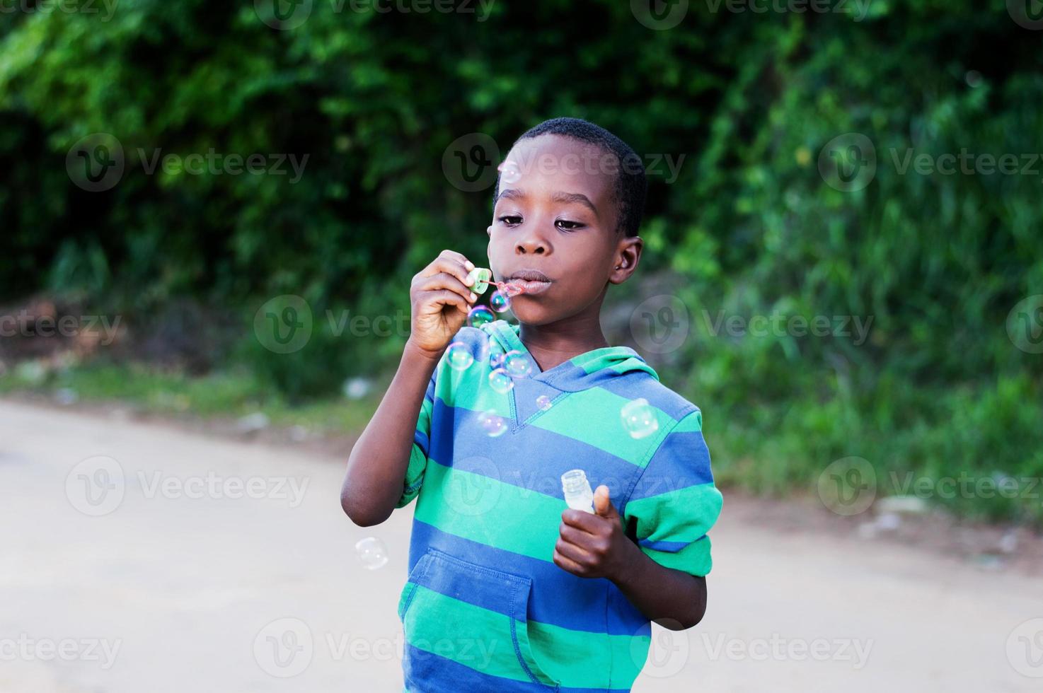 niño soplando burbujas. foto