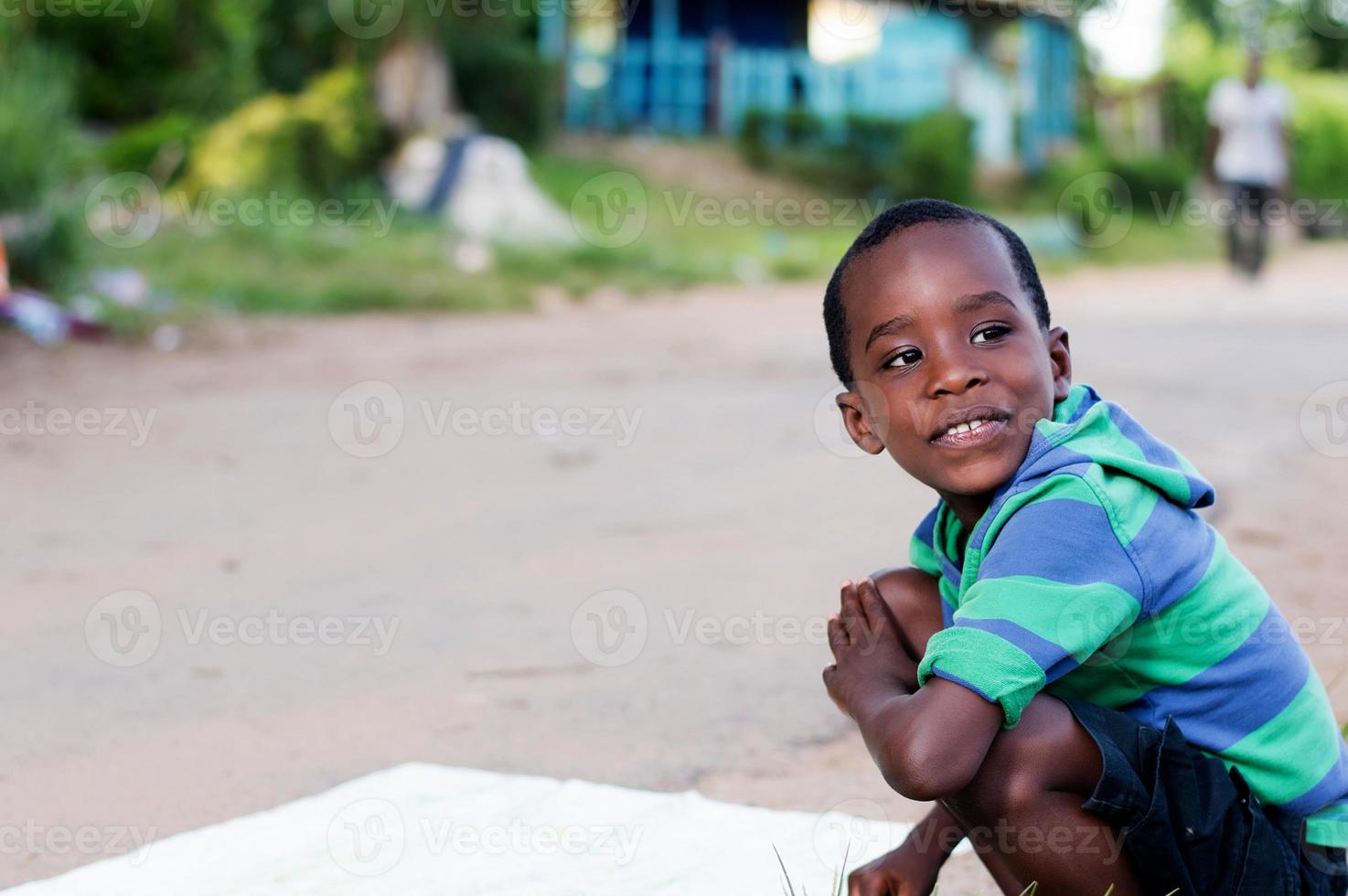 cheerful child crouching at the edge of the road. photo