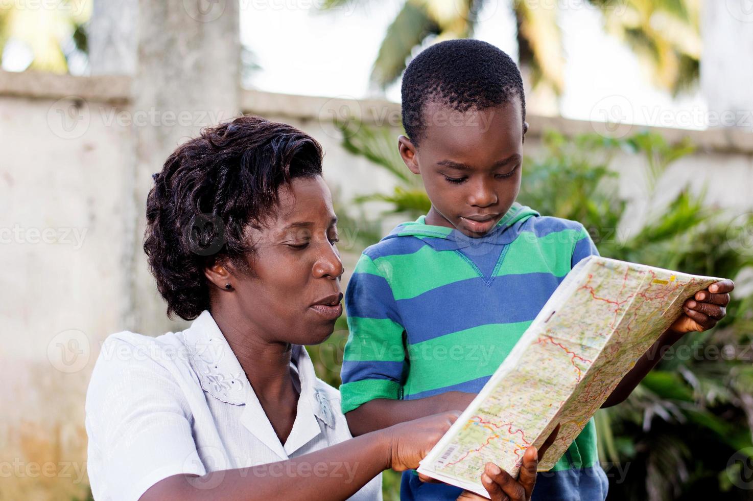 young woman reading a map with her child. photo