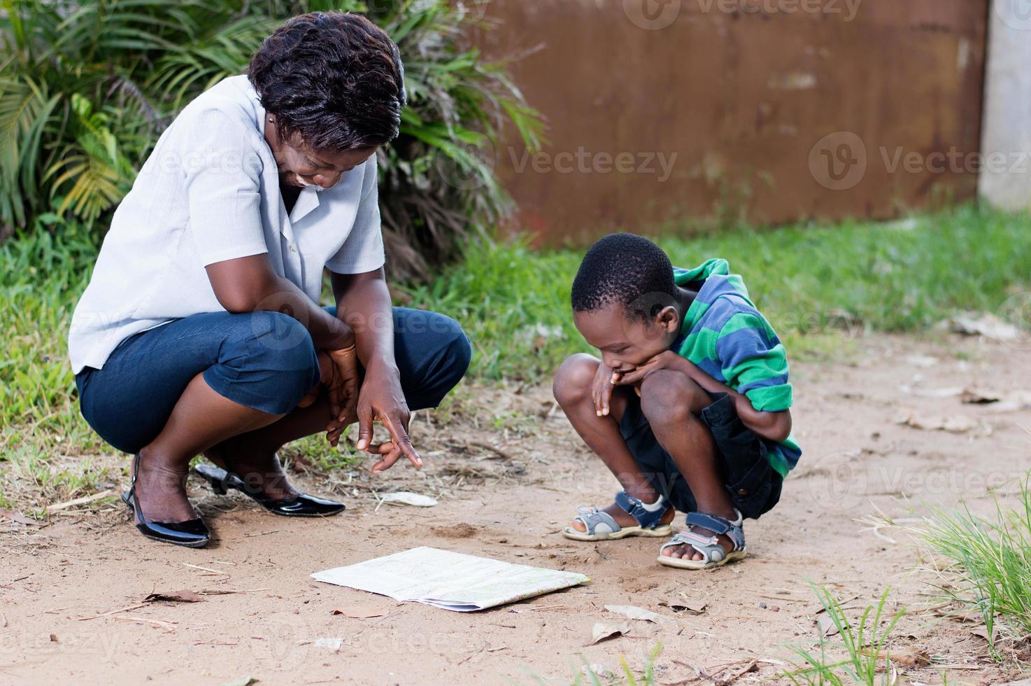 young woman reading a map with her child photo