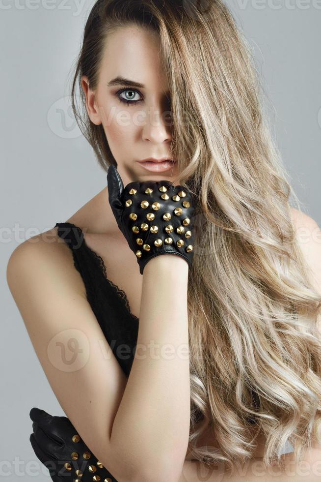 Woman with long hair and blue eyes wearing black lingerie and gloves photo