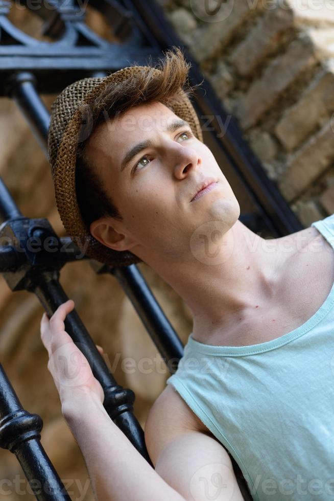 Handsome man wearing sun hat in urban background photo