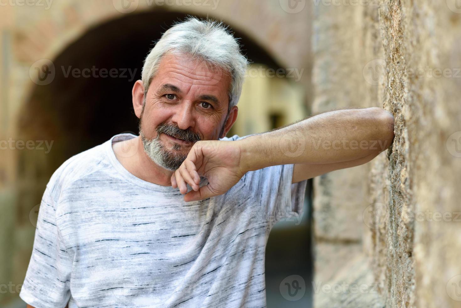 Mature man smiling looking at camera in urban background photo