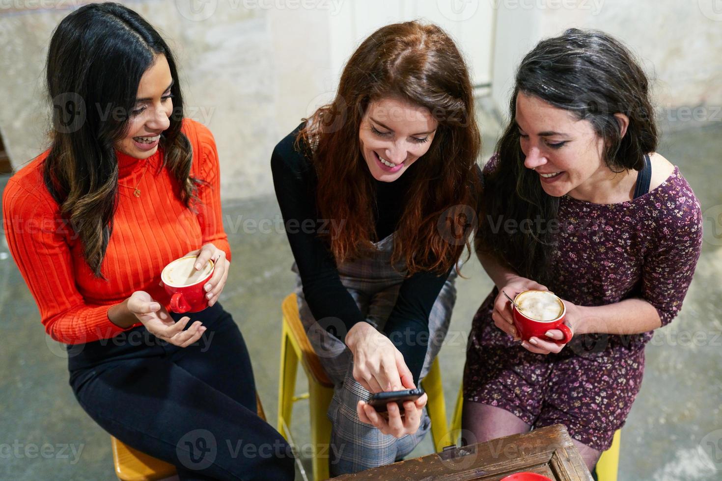 grupo de tres amigos felices tomando café en un bar cafetería. foto