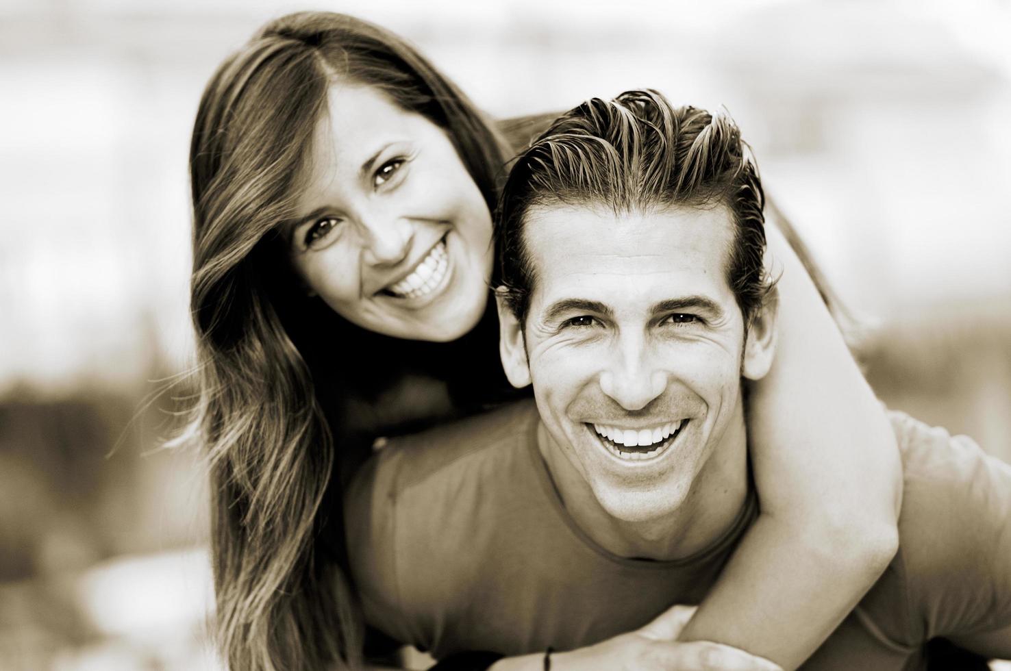 Smiling young man piggybacking his pretty girlfriend photo