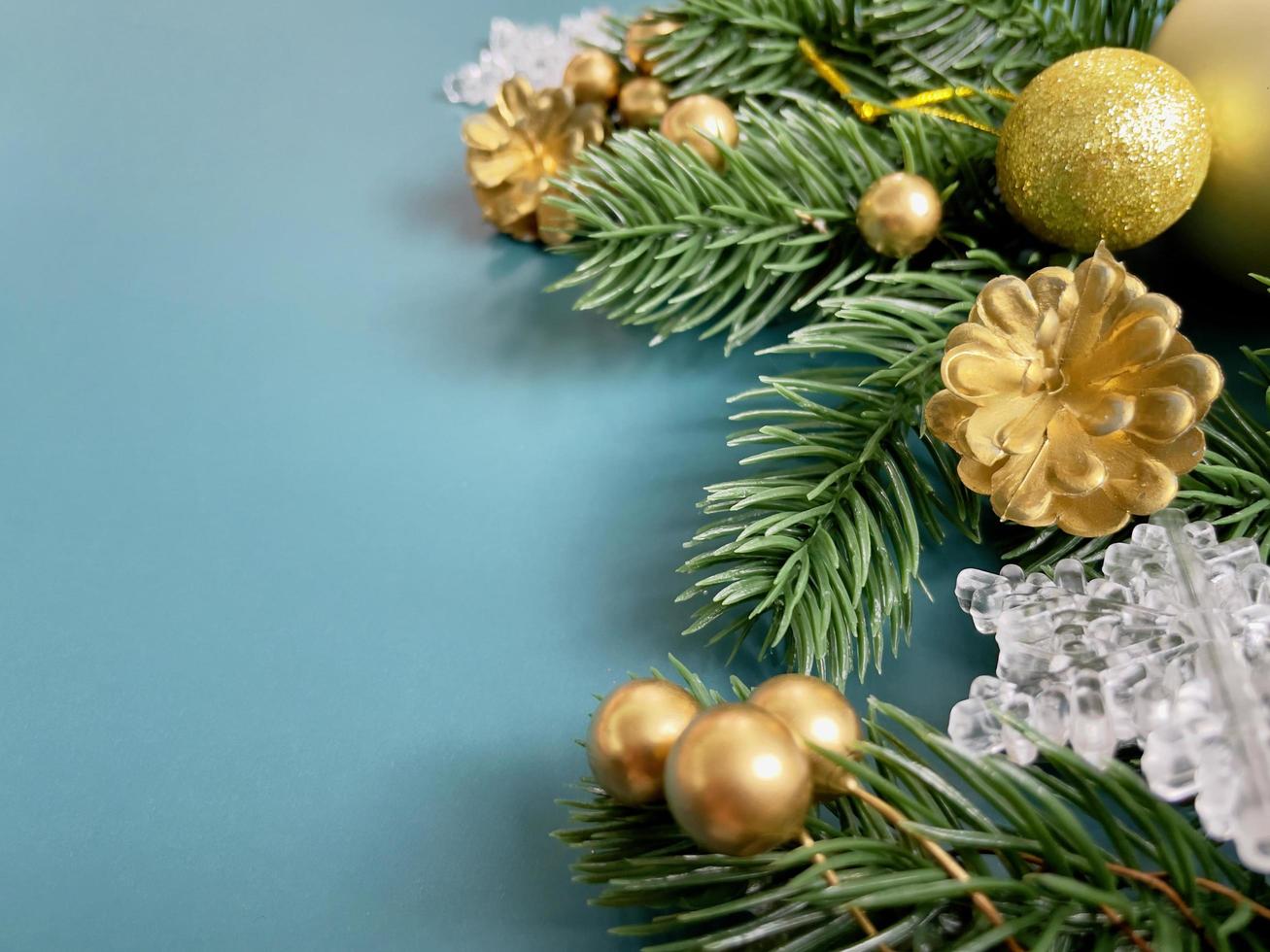 Christmas decorations, pine tree leaves, golden balls, snowflakes, golden berries on blue background photo